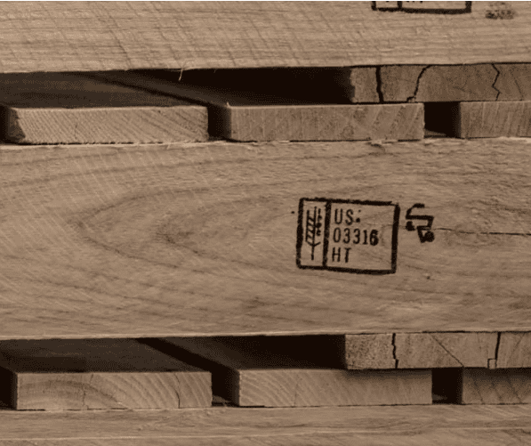 Labelled diagram of an ISPM 15 IPPC stamp showing country code, producer code, and HT heat treatment marking on a timber pallet