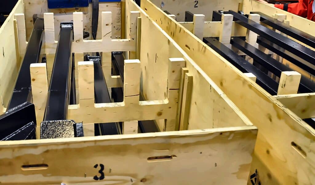 Internal plywood divisions and dunnage inside a Clip-Lok crate separating automotive components in transit