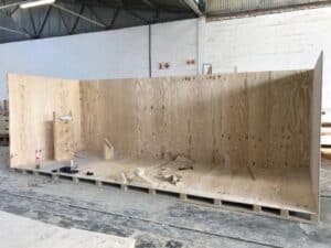 Long reusable plywood crate with reinforced edges for heavy equipment