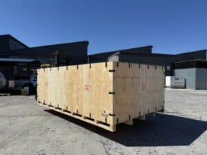 Large collapsible plywood transit crate on pallet base, outdoors ready for loading